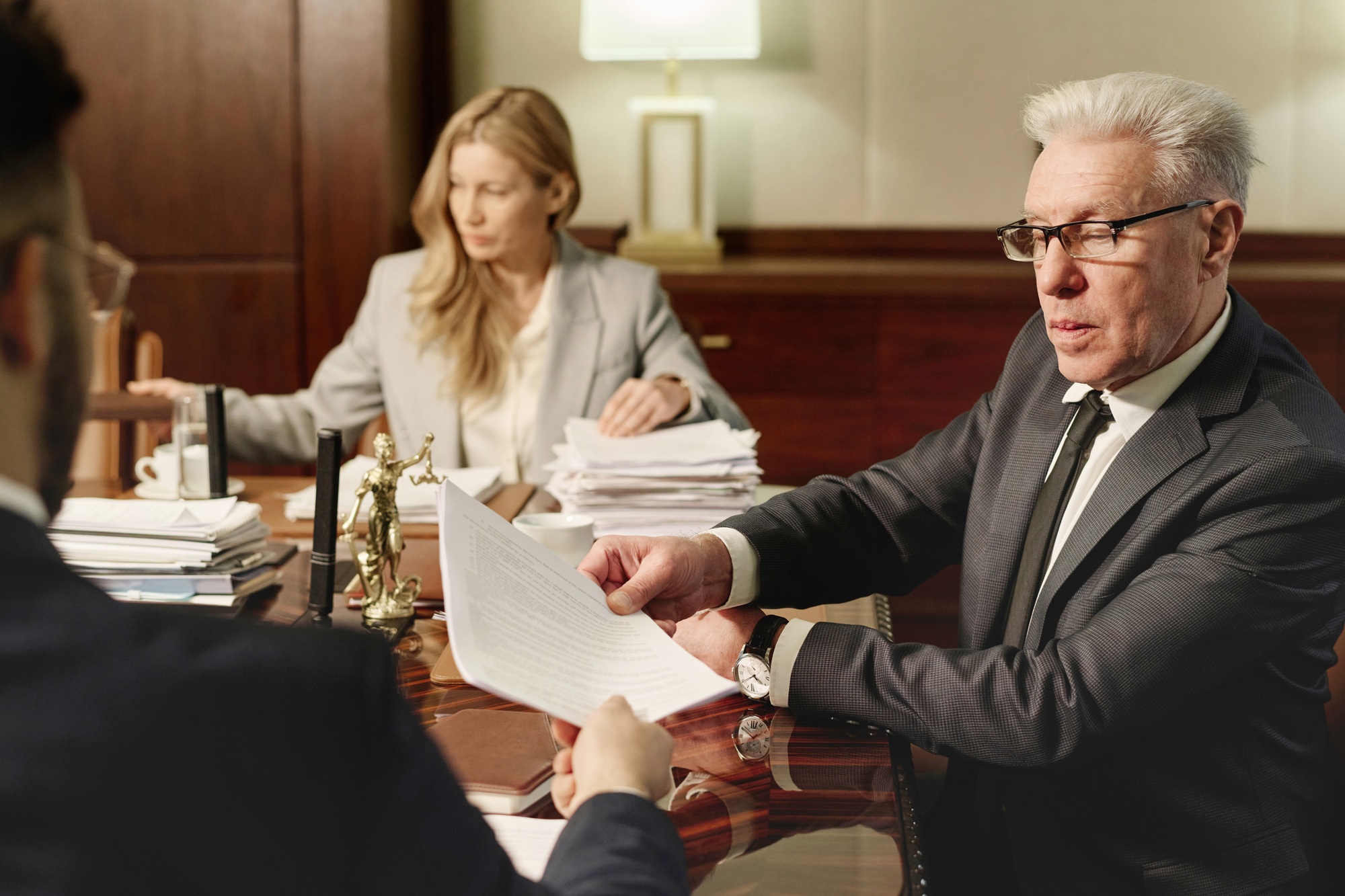 Experienced Attorneys Working with Documents Sitting in Office