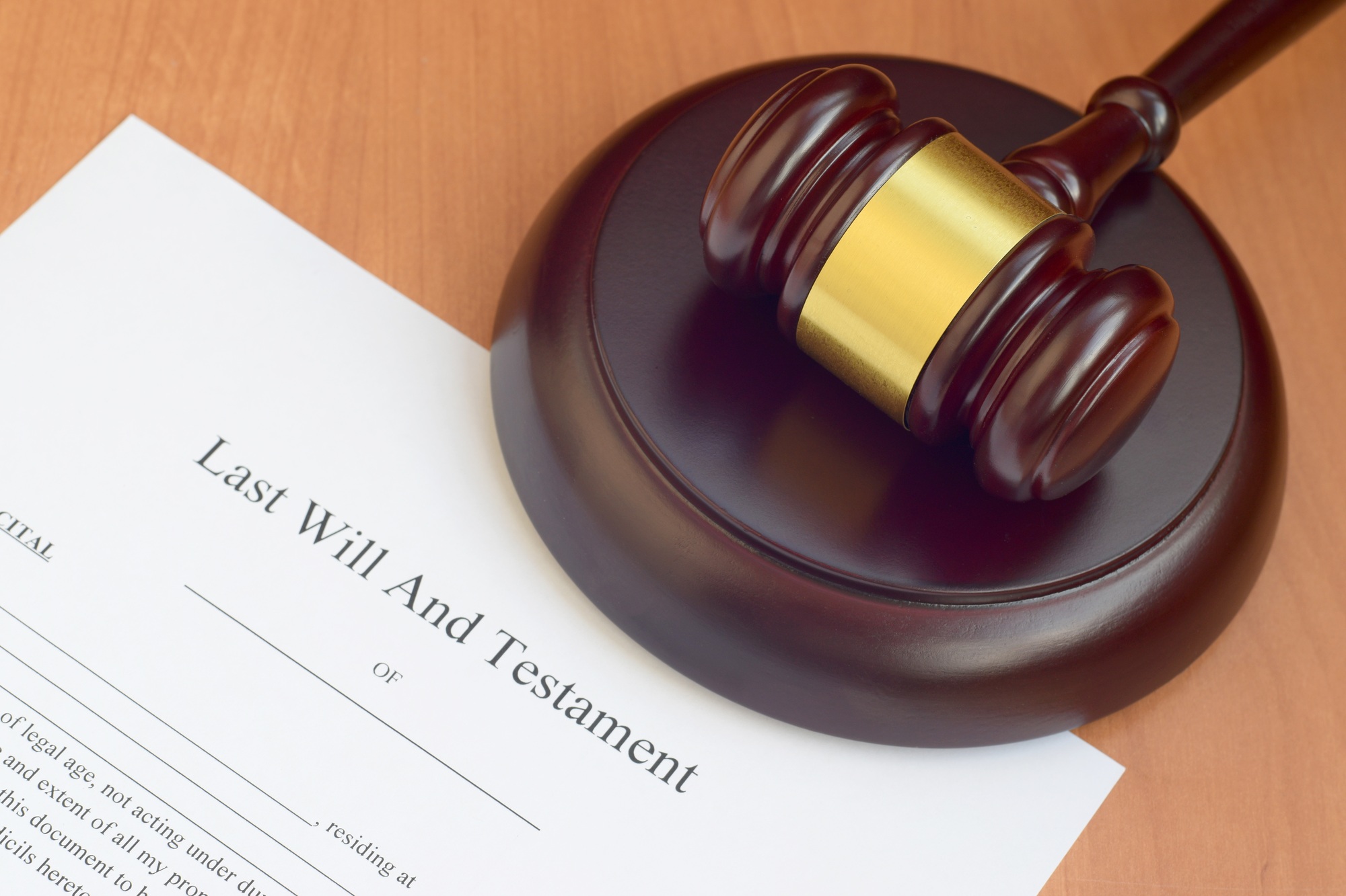 Justice mallet and Last Will and Testament blank document on wooden court table